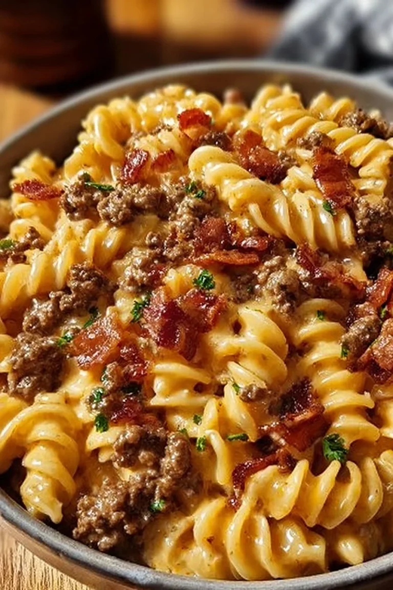A bowl of loaded bacon cheeseburger pasta garnished with crispy bacon and cheese