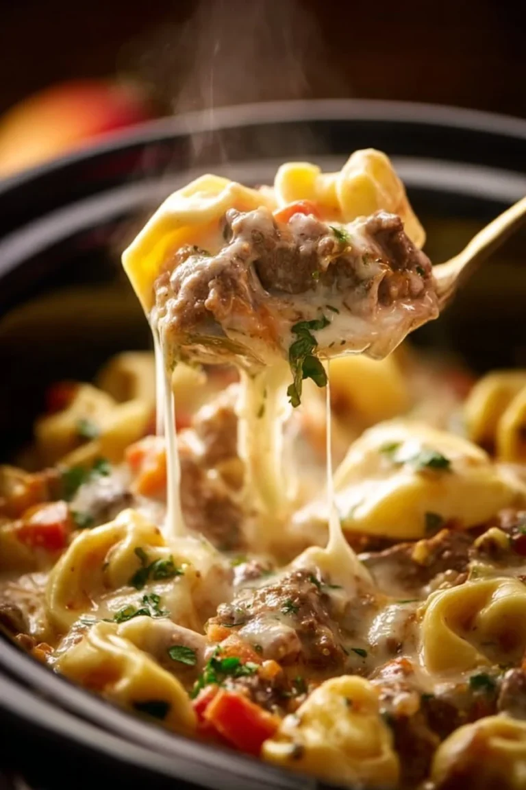 Crock Pot Cheesesteak Tortellini served in a bowl with melted cheese and herbs