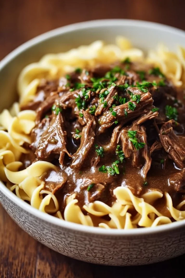 Delicious slow cooker beef noodles topped with fresh herbs.